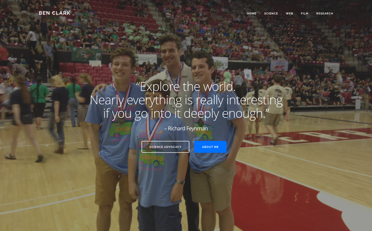 The homepage of my portfolio site: a full-bleed photo of three teenagers in medals on a basketball court, overlaid with a Feynman quote, “Explore the world. Nearly everything is really interesting if you go into it deeply enough.”, and buttons reading Science Advocacy and About Me